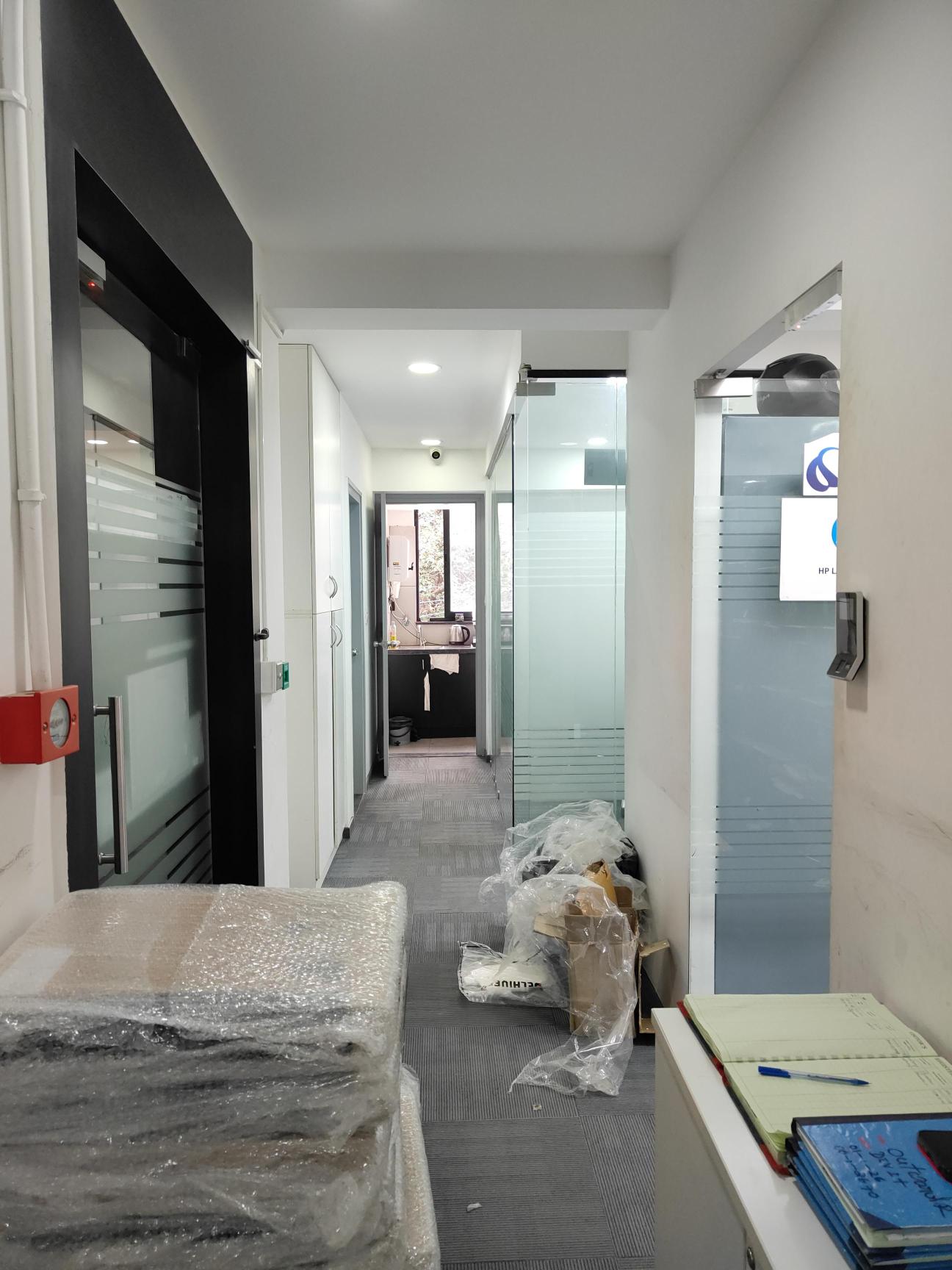 Dev IT Serv office corridor with packaged equipment prepared for handling